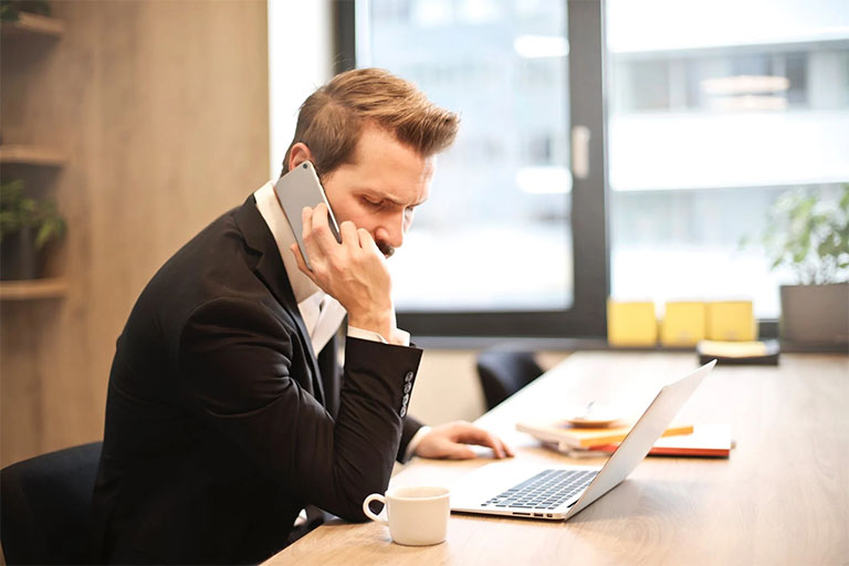 man-with-computer Business man on cell phone at a desk