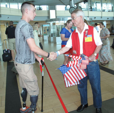 Veteran and a man holding US flags